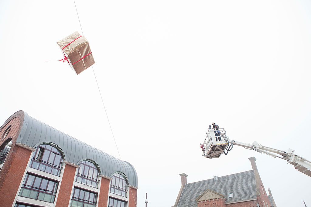 Een cadeau wordt tijdens de intocht van 2012 naar beneden gebracht