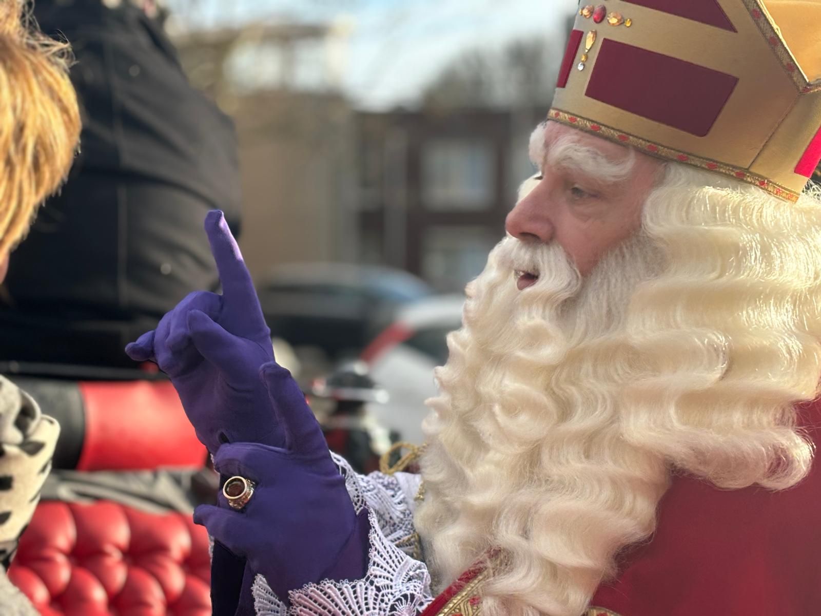 Sinterklaas begroet iemand langs de route